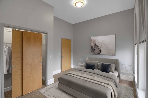 A bedroom with a large bed and a painting on the wall.at The Granite Works Apartments , Buffalo